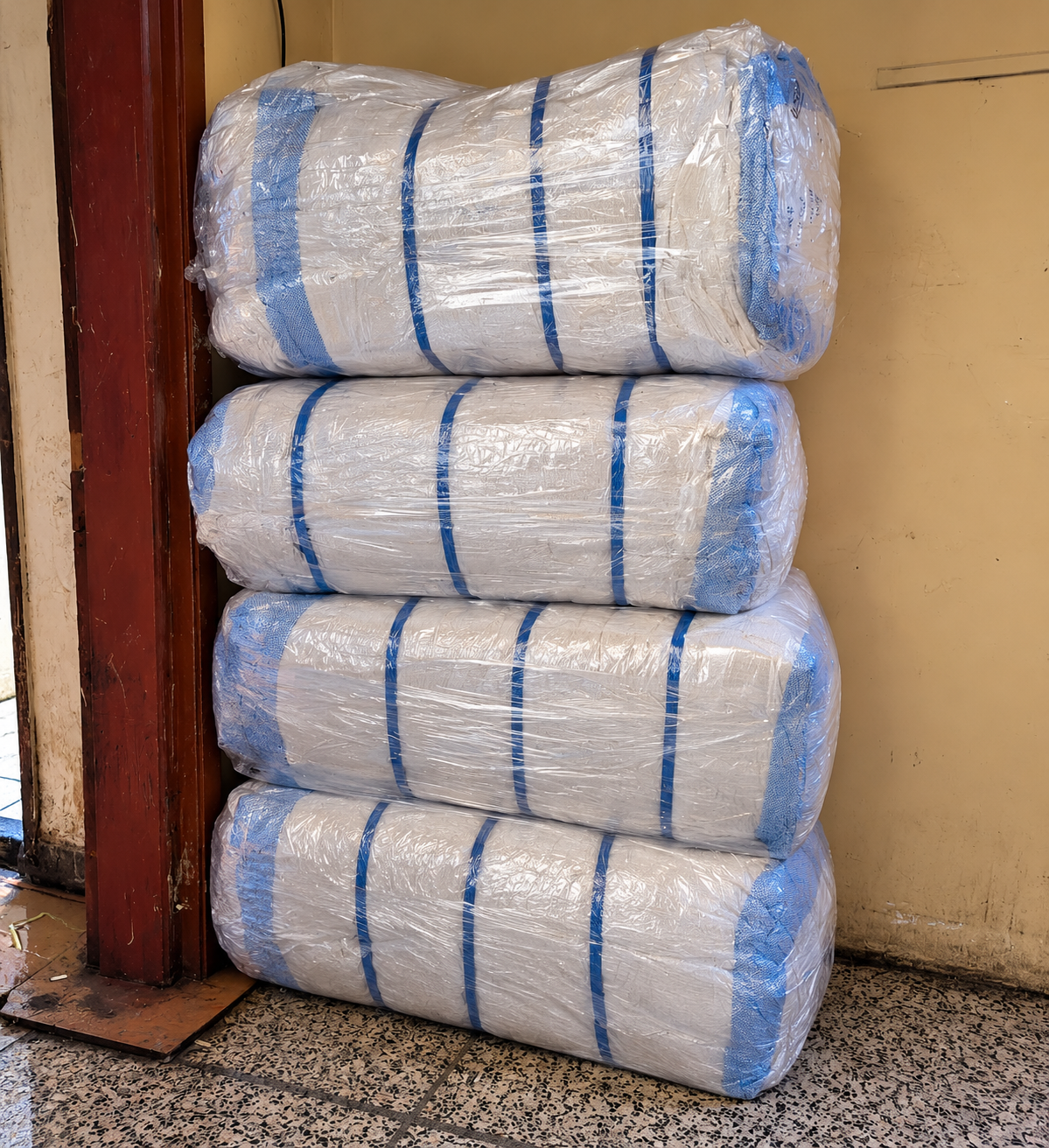 Protective-wrapped furniture cargo bundles secured with blue straps for shipment from Deira Dubai to Lahore Pakistan